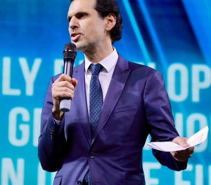 Ali Aslan speaking on stage at an international conference